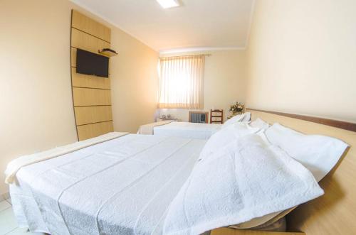 a bedroom with a large white bed in a room at Antico Plaza Hotel in Taubaté