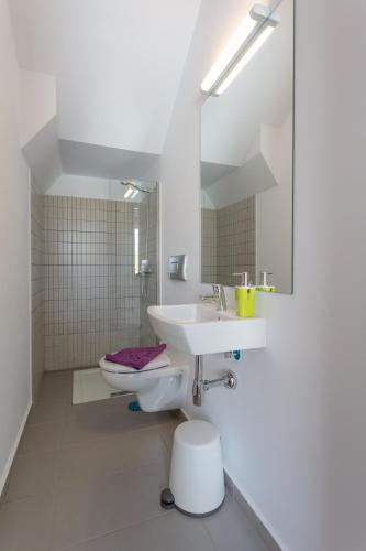 a white bathroom with a sink and a toilet at Mariposas Home Pool in Puerto del Rosario