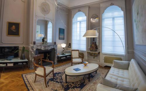 
a living room filled with furniture and a large window at Louise sur Cour in Brussels
