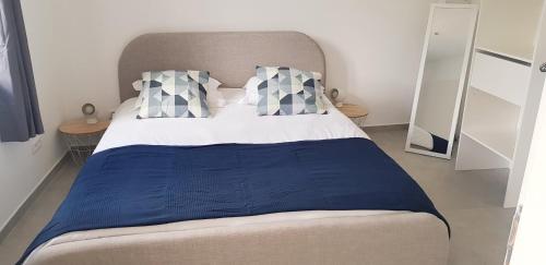 a bedroom with a bed with a blue blanket and pillows at Côté Verdon in Quinson