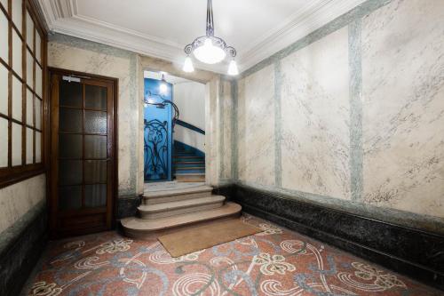 an empty hallway with stairs and a blue door at Marais Renard in Paris