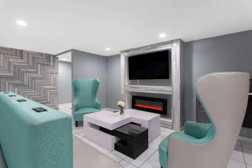 a living room with two chairs and a fireplace at University Inn & Suites in Charlotte