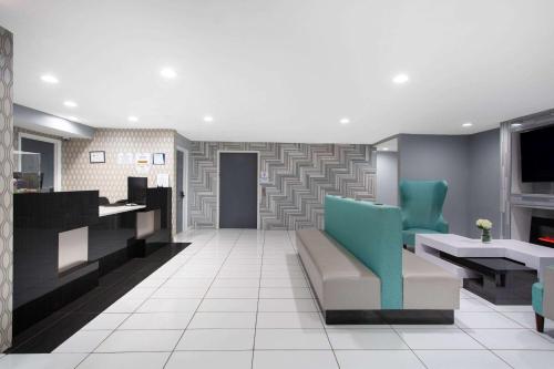 a lobby with blue chairs and a waiting room at University Inn & Suites in Charlotte