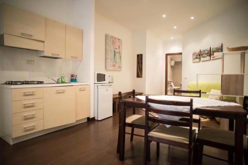 eine Küche und ein Esszimmer mit einem Tisch und eine Küche mit einem Kühlschrank in der Unterkunft Appartamento Belvedere in Monte Terminillo
