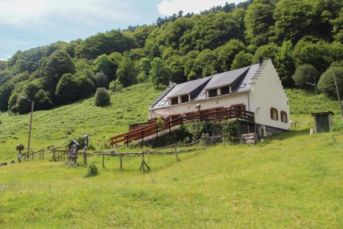 une maison sur une colline dans un champ herbeux dans l'établissement Ô Chiroulet - Le Refuge de l'Isard, à Bagnères-de-Bigorre