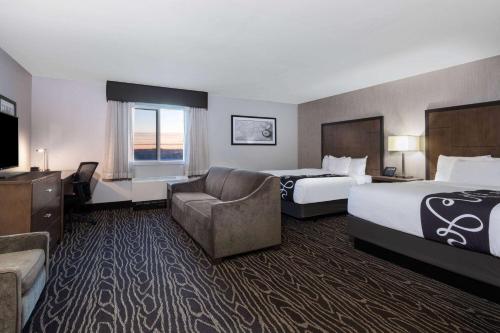 a hotel room with two beds and a couch at La Quinta by Wyndham Fairbanks Airport in Fairbanks
