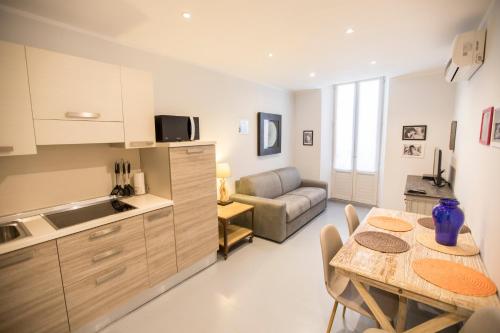 une cuisine et un salon avec une table et un canapé dans l'établissement Résidence Bouttau by Connexion, à Cannes