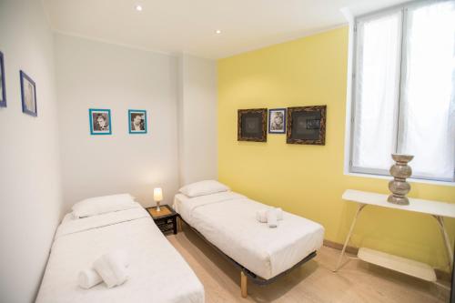 2 letti in una camera con pareti gialle e finestra di Résidence Bouttau by Connexion a Cannes