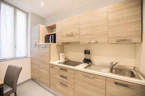 una cucina con mobili in legno e un lavello di Résidence Bouttau by Connexion a Cannes