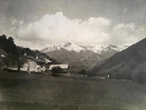 uma velha foto a preto e branco de uma casa e montanhas em Résidence La Chaumière em Les Gets