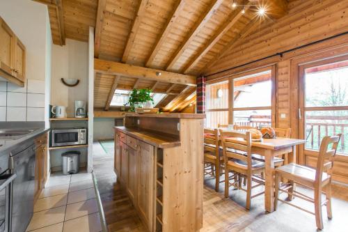 a kitchen and dining room with a wooden ceiling at Résidence La Chaumière in Les Gets