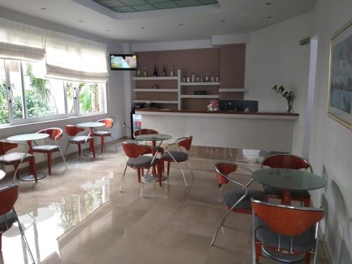 a restaurant with tables and chairs and a counter at Apollo Hotel in Athens