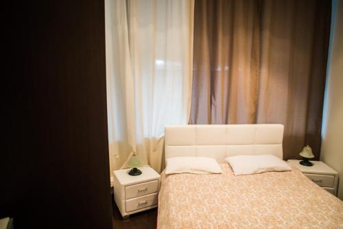 1 dormitorio con 1 cama blanca y 2 mesitas de noche en Finestra sulla Funivia, en Terminillo
