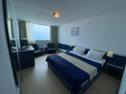 Cette chambre d'hôtel dispose d'un lit avec une couverture bleue. dans l'établissement Hotel Venus, à Vénus