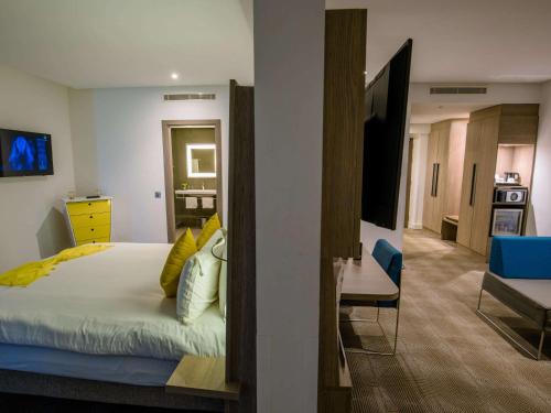 a bedroom with a bed and a living room at Novotel Mohammedia in Mohammedia