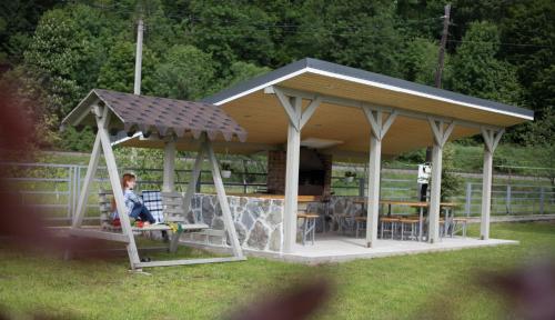 a child sitting on a swing in a gazebo at Lucy in Yaremche