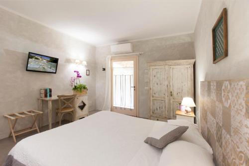 a bedroom with a white bed and a window at B&B Le Cascatelle di Saturnia in Saturnia