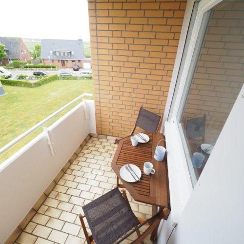 un balcón con una mesa y 2 sillas en un porche en Appartement-147, en Westerland