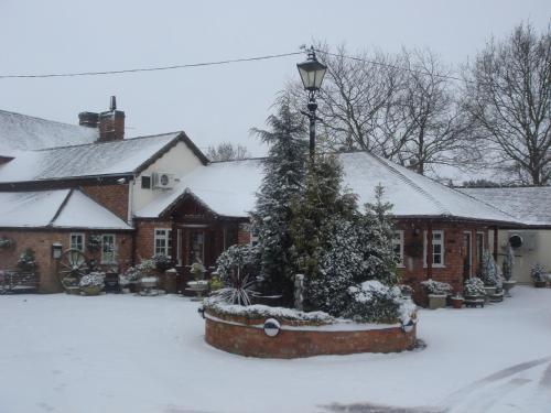 a house with a christmas tree in the snow at The Royal Arms Hotel in Sutton Cheney