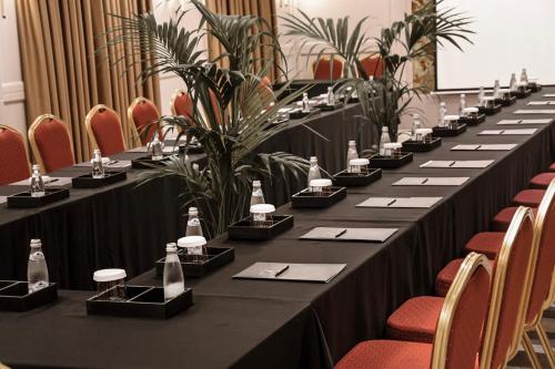 a long table in a room with chairs and plants at Flower Hotels & Resorts in Golem