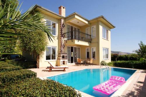 una casa con piscina frente a una casa en Goldcity Hotel, en Kargicak