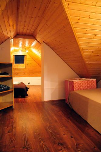 an attic room with a bed and a staircase at Greenapple Apartman Badacsony in Badacsonytördemic
