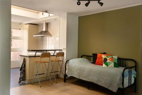 ein Schlafzimmer mit einem Bett neben einer Küche in der Unterkunft Zee en Strand Vlissingen in Vlissingen