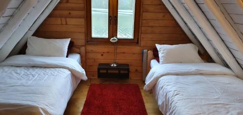 two beds in a room with two windows at Traditional Casa Pescarului langa lac cu ponton in Colibiţa