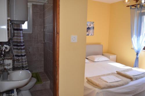a bathroom with a bed and a sink and a shower at Apartments Aneva in Baška