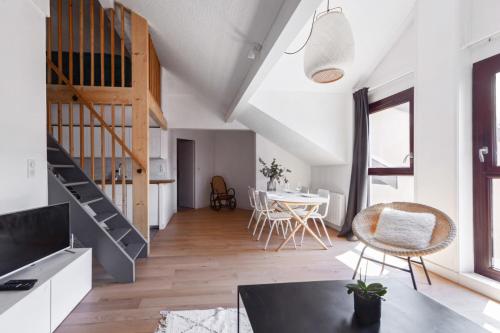 une pièce avec un escalier, une table et des chaises dans l'établissement Duplex Volland - Welkeys, à Annecy