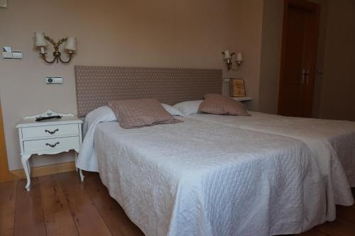 a bedroom with a bed and a nightstand with a white bedspread at Arganzón Plaza in La Puebla de Arganzón
