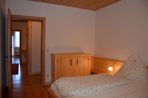 a bedroom with a bed and a wooden cabinet at Pension zum Schreiner in Hermagor