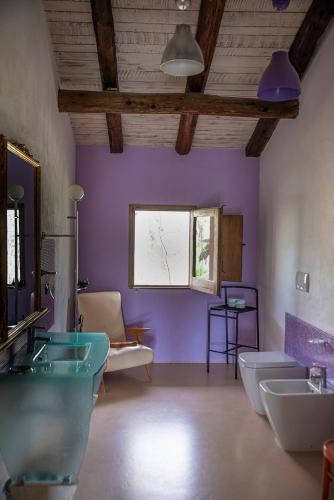 a bathroom with two sinks and purple walls at Il giardino dei mandorli Agriturismo in Alatri