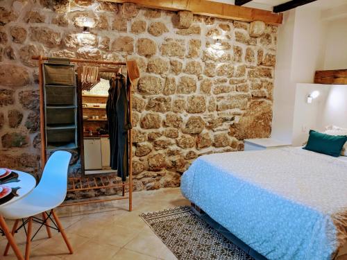 a bedroom with a bed and a stone wall at Romantic Rooftop View Hideaway- Old Town Nr 404 in Kotor