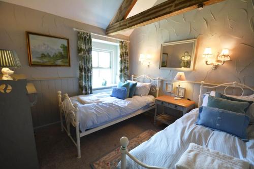 a bedroom with two beds and a window at Haddon Grove Farm Cottages in Bakewell