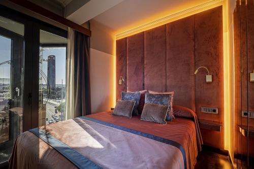 1 dormitorio con 1 cama y ventana grande en ON Suites Sevilla Apartments designed for adults en Sevilla