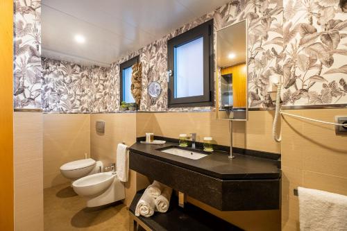 y baño con lavabo, aseo y espejo. en ON Suites Sevilla Apartments designed for adults, en Sevilla