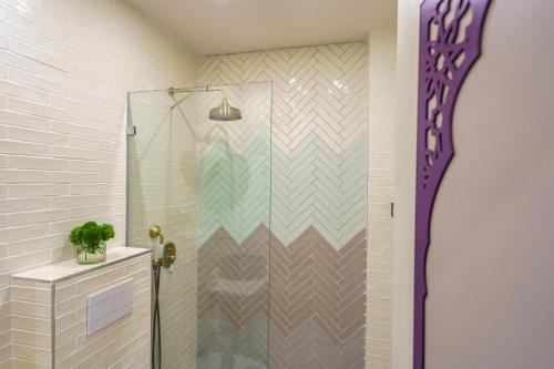 a shower with a glass door in a bathroom at The Way Inn - Boutique Suites in Safed