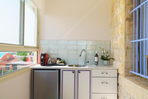 a kitchen with a sink and a window at The Way Inn - Boutique Suites in Safed