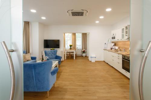 kuchnia z niebieskimi krzesłami i salon w obiekcie Apartments Villa Whitehouse w Ostravie
