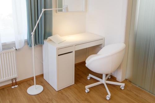 a white desk and a chair in a room at Apartments Villa Whitehouse in Ostrava