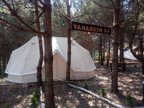 a white tent in the woods with a street sign at Kompleks Małe Dolomity in Hucisko