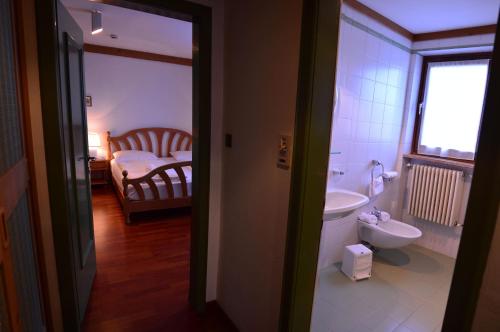 W pokoju znajduje się łazienka z umywalką i toaletą. w obiekcie Appartamenti Astoria La Villa w mieście La Villa