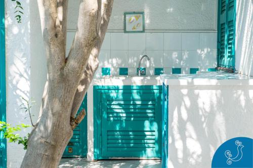 a blue door in a kitchen with a tree at Villa Turchese - Exclusive dimora on the beach in Geremèas