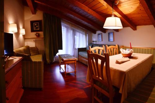 jadalnia ze stołem i salonem w obiekcie Appartamenti Astoria La Villa w mieście La Villa