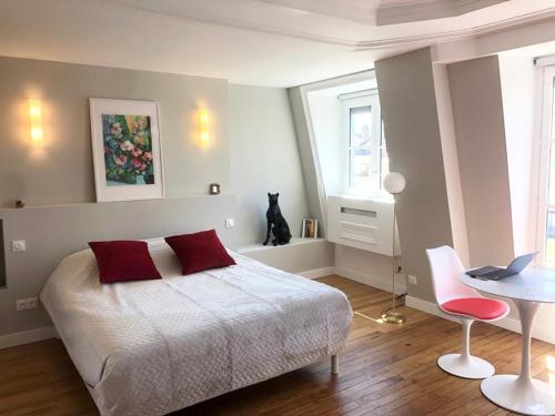 - une chambre avec un lit, une table et un chat dans l'établissement Celect'In Lyon Suites climatisées SkyView, à Lyon