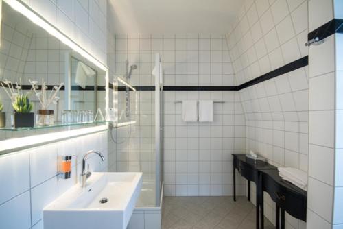 a white bathroom with a sink and a mirror at Die Villa in Mannheim