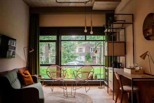 a living room filled with furniture and a window at Hotel V Fizeaustraat in Amsterdam