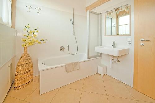 a bathroom with a sink and a bath tub and a mirror at Villa Trogerhof in Ora/Auer