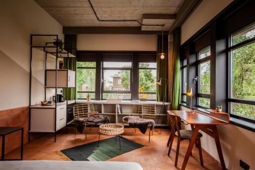 een woonkamer met een tafel, stoelen en ramen bij Hotel V Fizeaustraat in Amsterdam